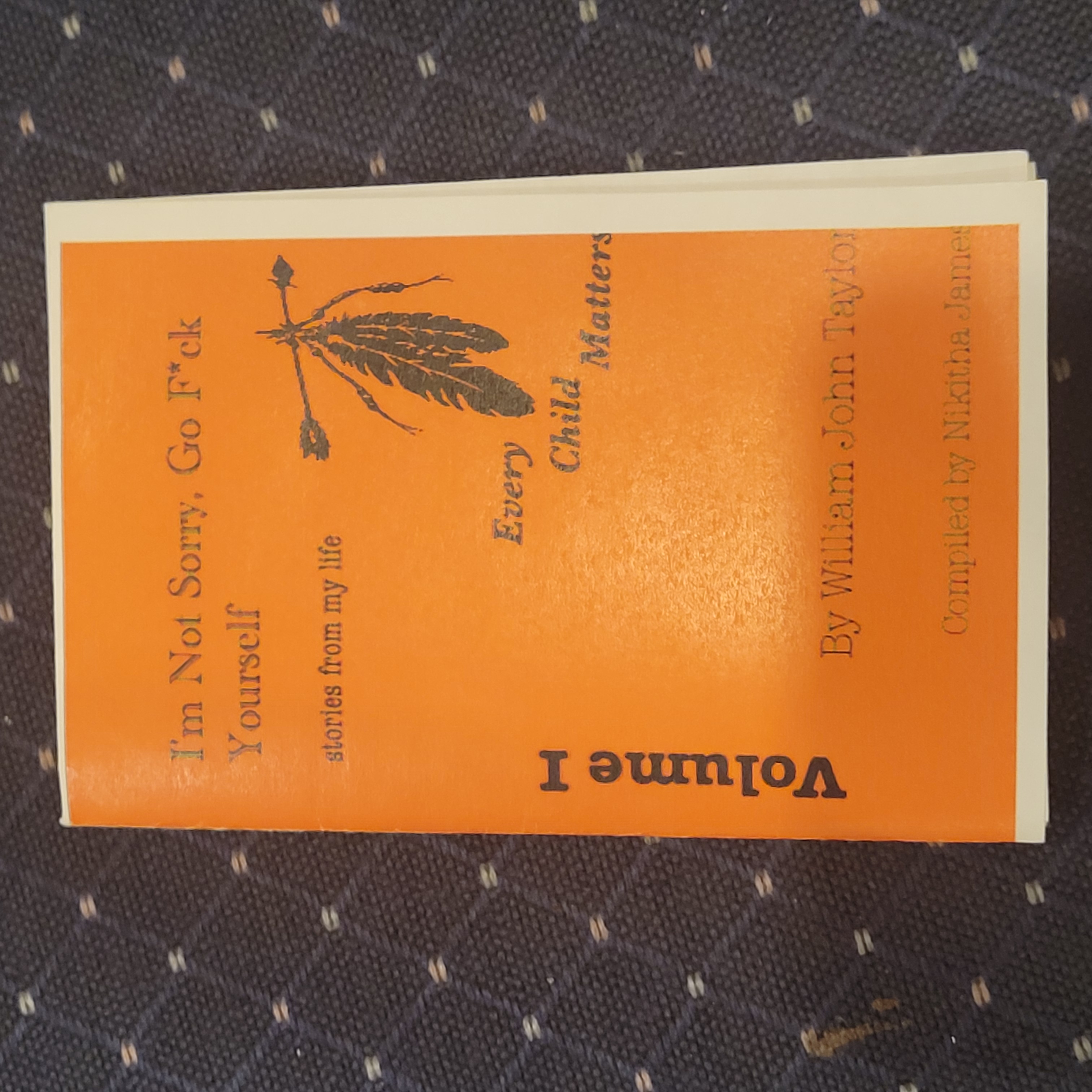 Orange cover, black silhouette of two upside down feathers tied together and an arrow through the base of the feathers