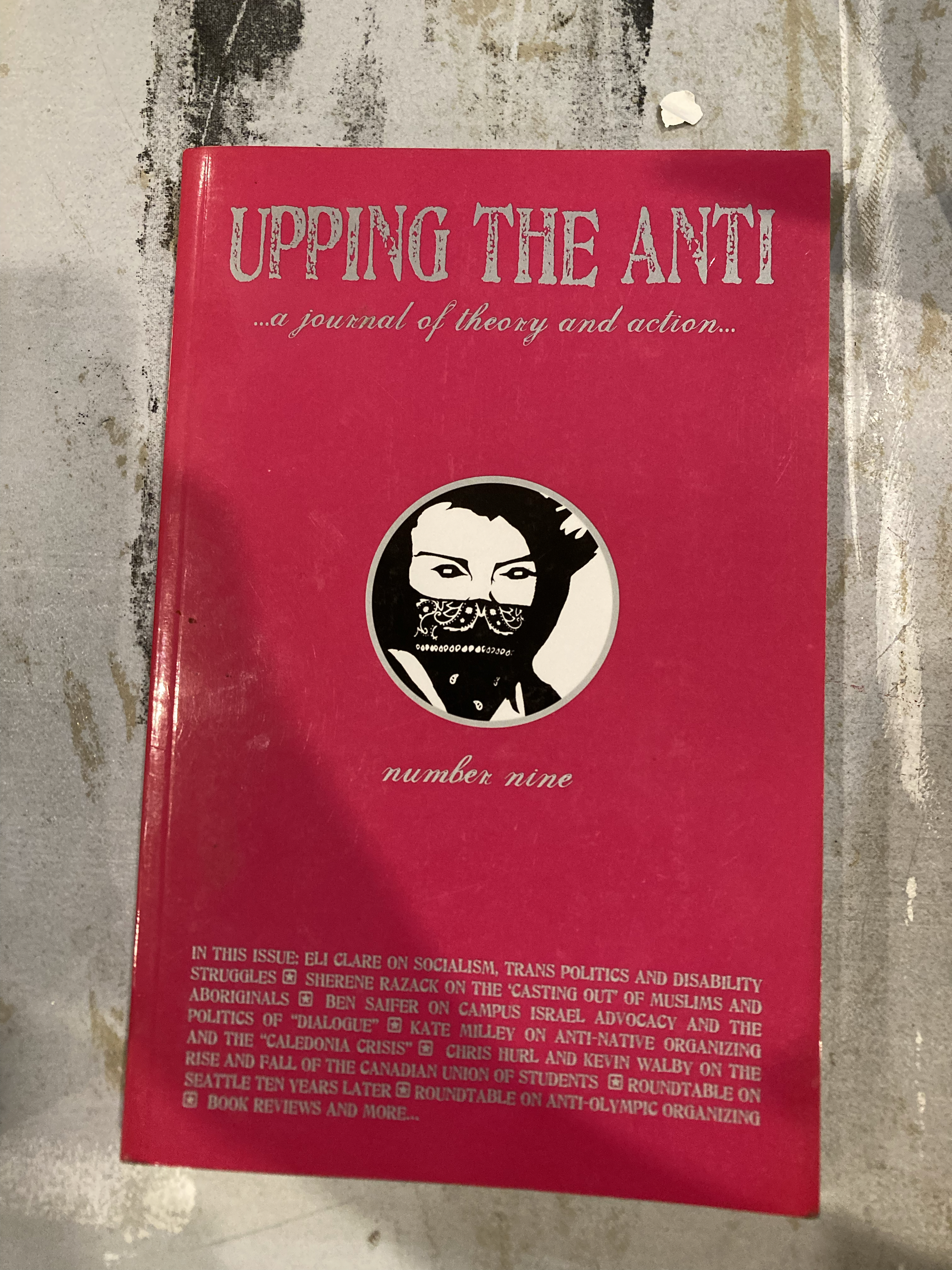 pink cover with black and white illustration of a person wearing a bandana mask